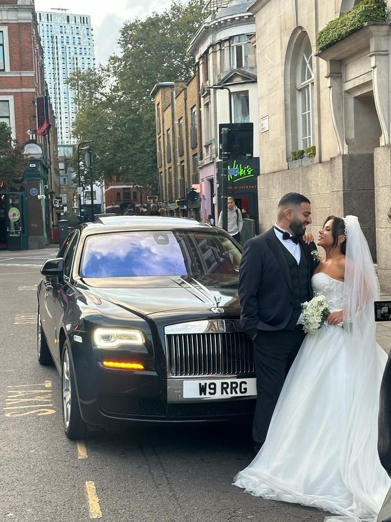 Couple with black Rolls-Royce Ghost at country house wedding