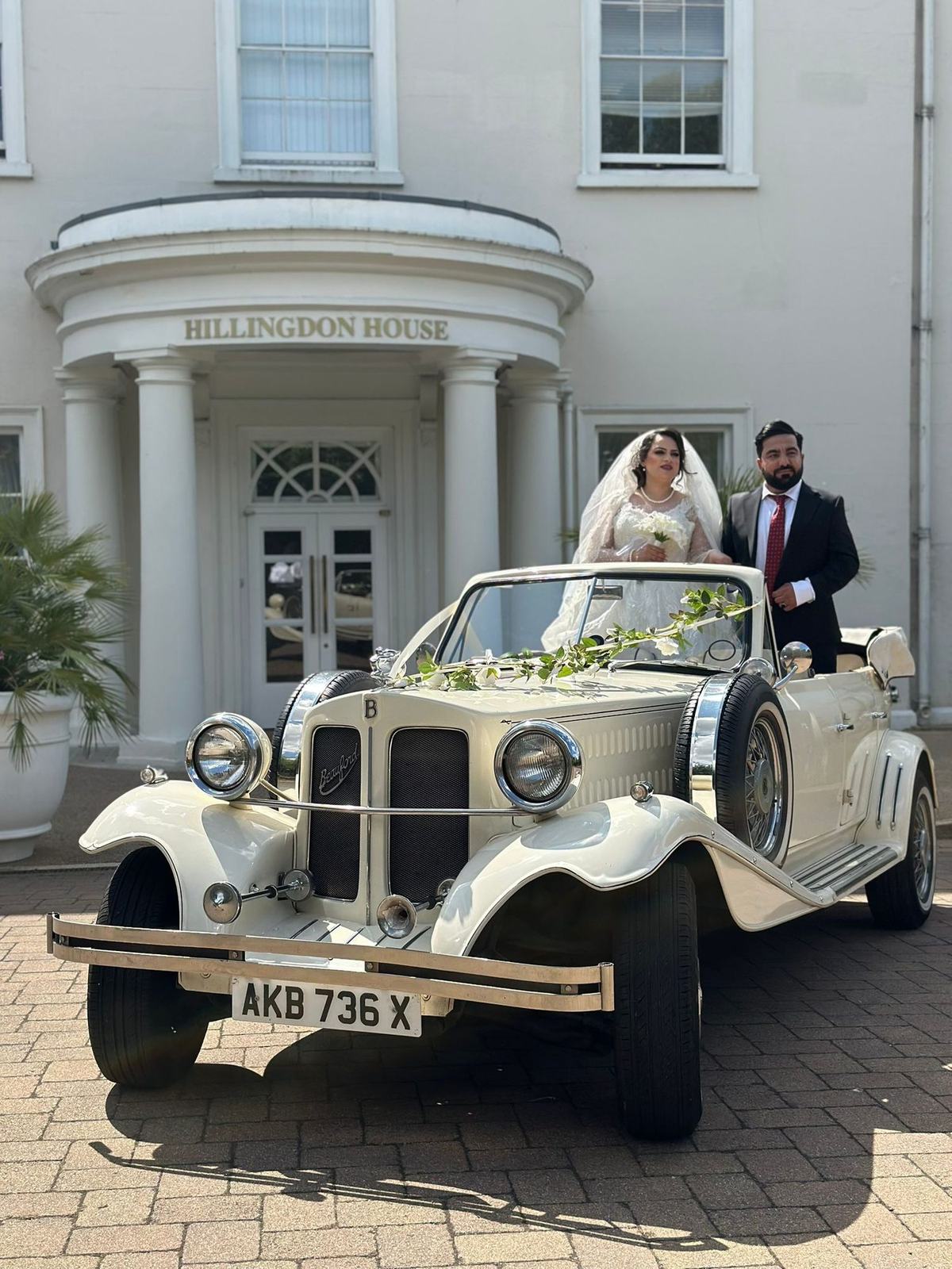 Asian wedding couple with white Rolls-Royce Phantom in woodland